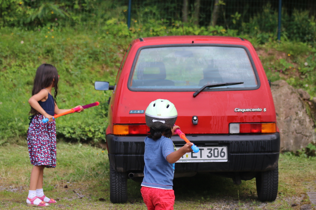 Kids spraying water on a car